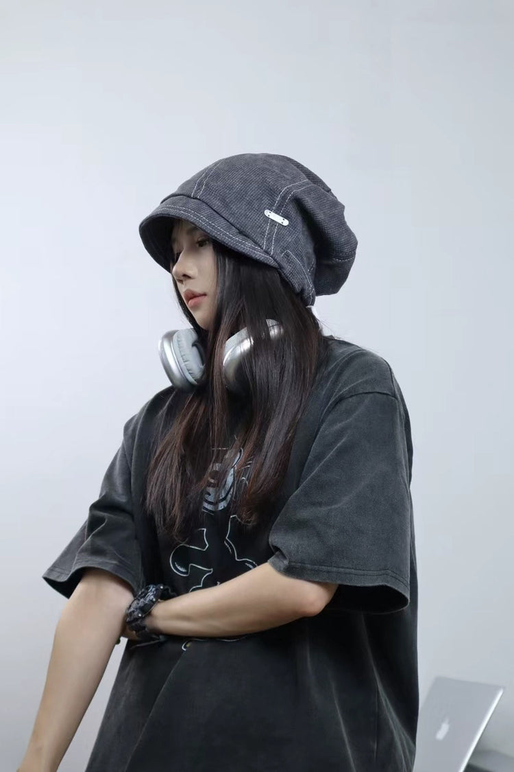 Person wearing a dark hoodie and headphones against a plain background