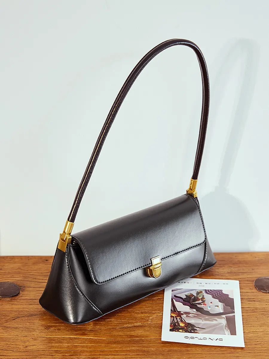 Black handbag with gold accents on a wooden surface