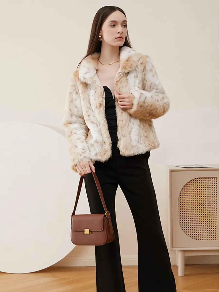 Woman wearing a beige faux fur jacket and holding a brown handbag indoors.