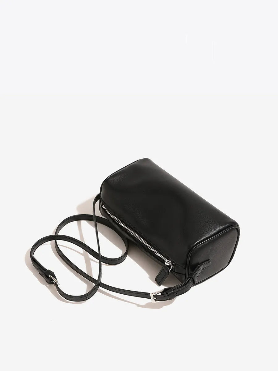 Black handbag with a strap on a white background