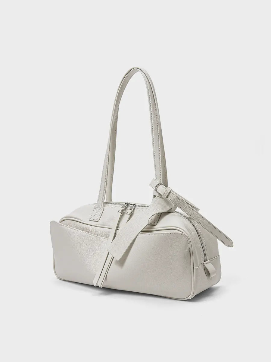 White handbag with a strap on a light gray background