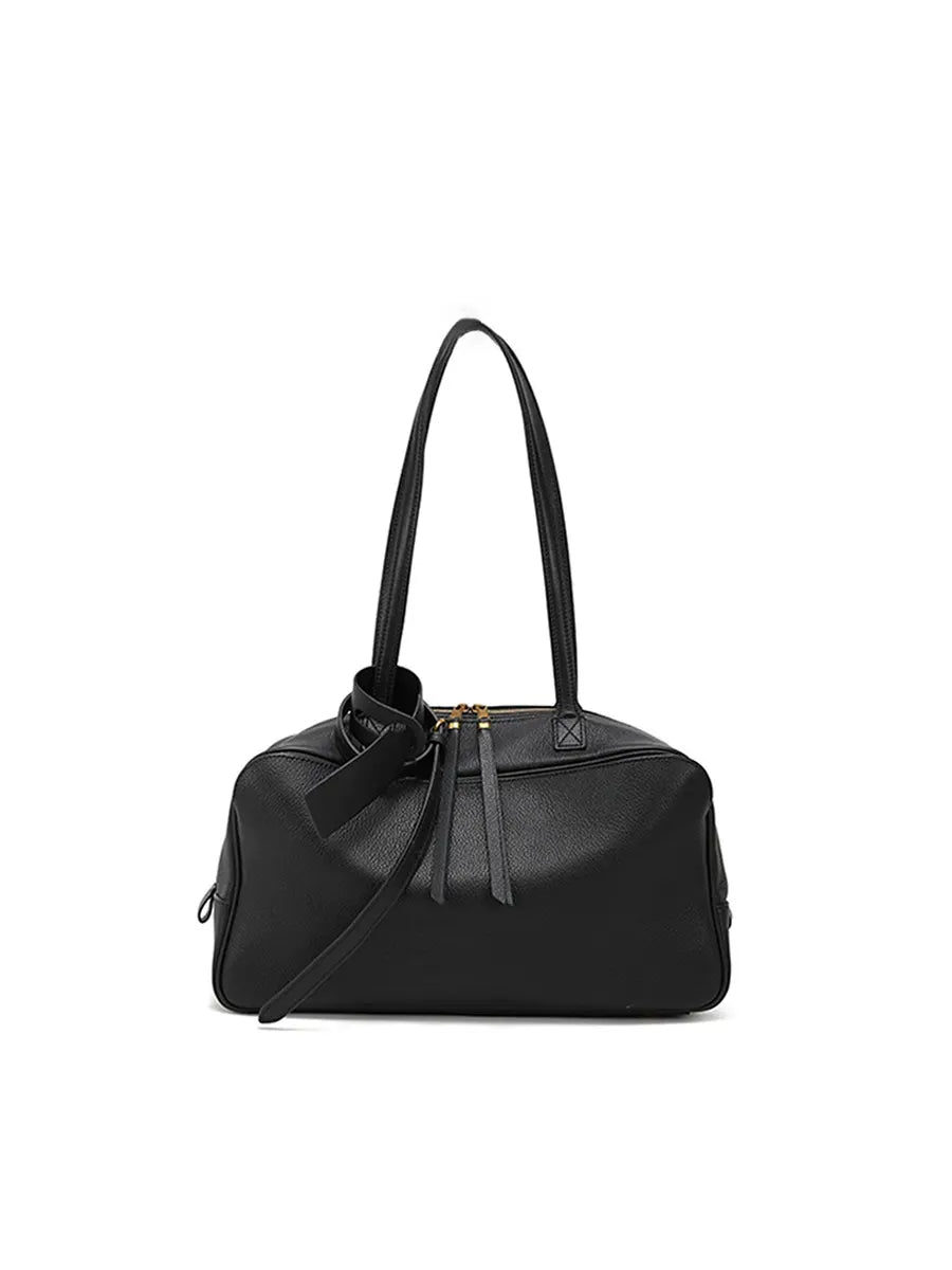 Black handbag with a strap on a white background