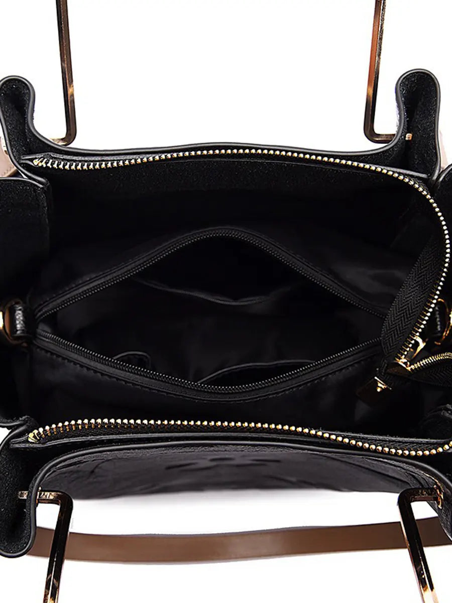 Black handbag with gold zipper details on a white background
