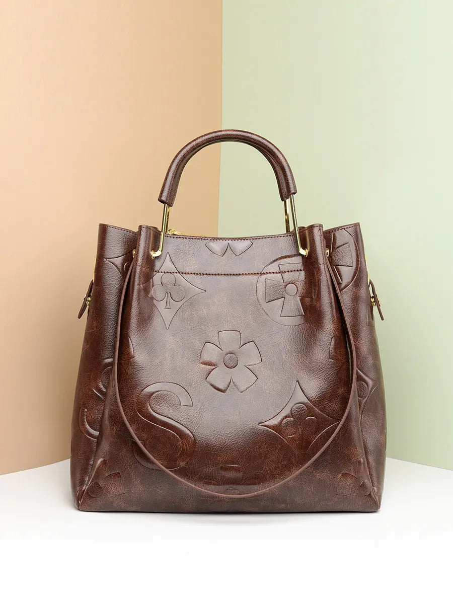 Brown leather handbag with floral and geometric embossing on a two-tone background