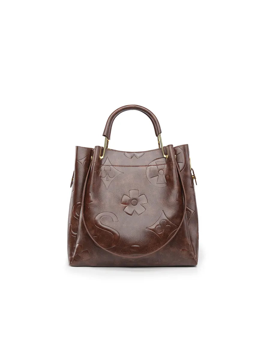 Brown leather handbag with floral design on a white background