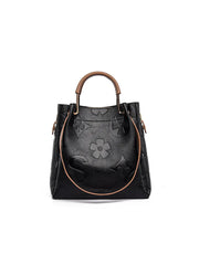 Black handbag with floral design on a white background