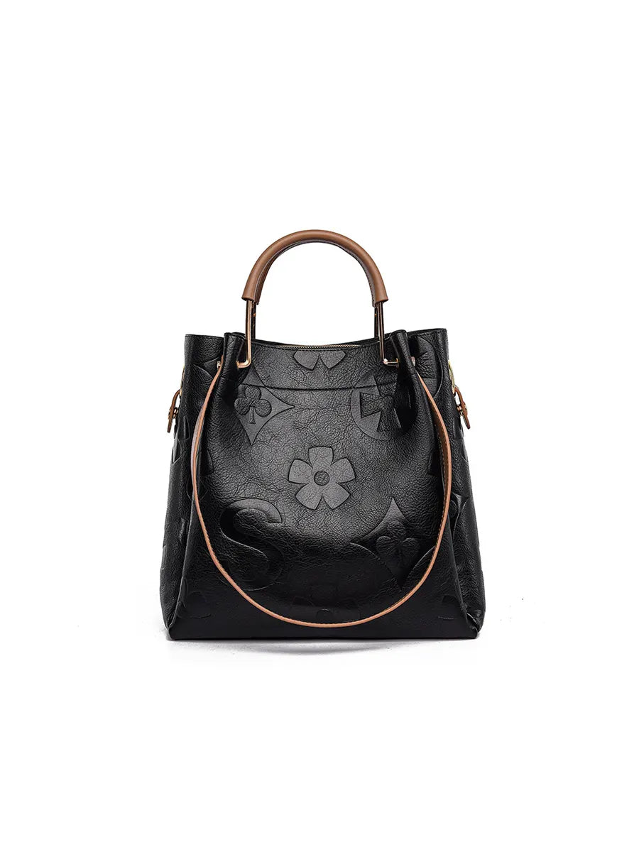 Black handbag with floral design on a white background