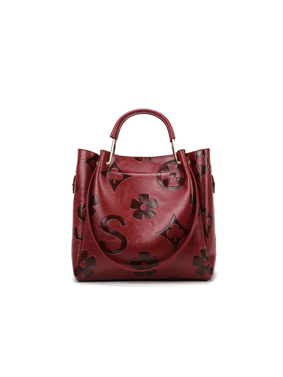 Red handbag with floral patterns on a white background
