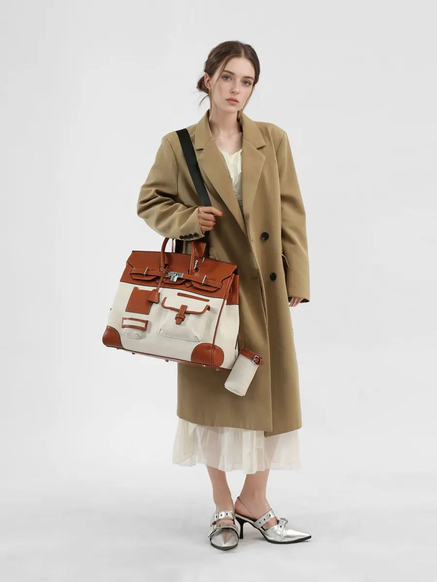Woman holding a brown and beige handbag against a white background