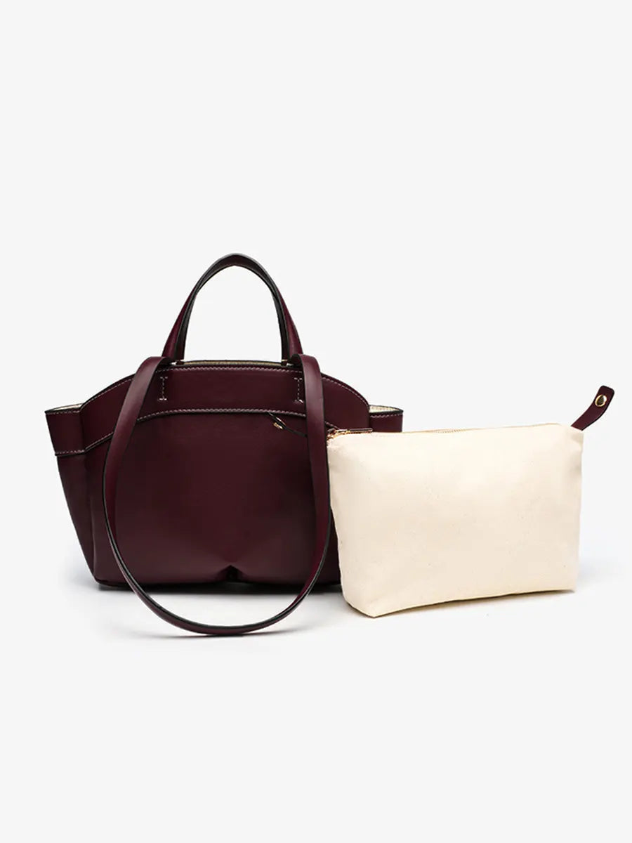 Burgundy handbag and beige pouch on a white background