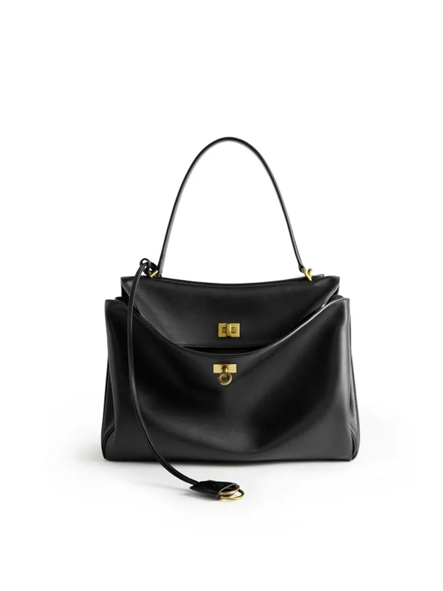 Black handbag with gold accents on a white background