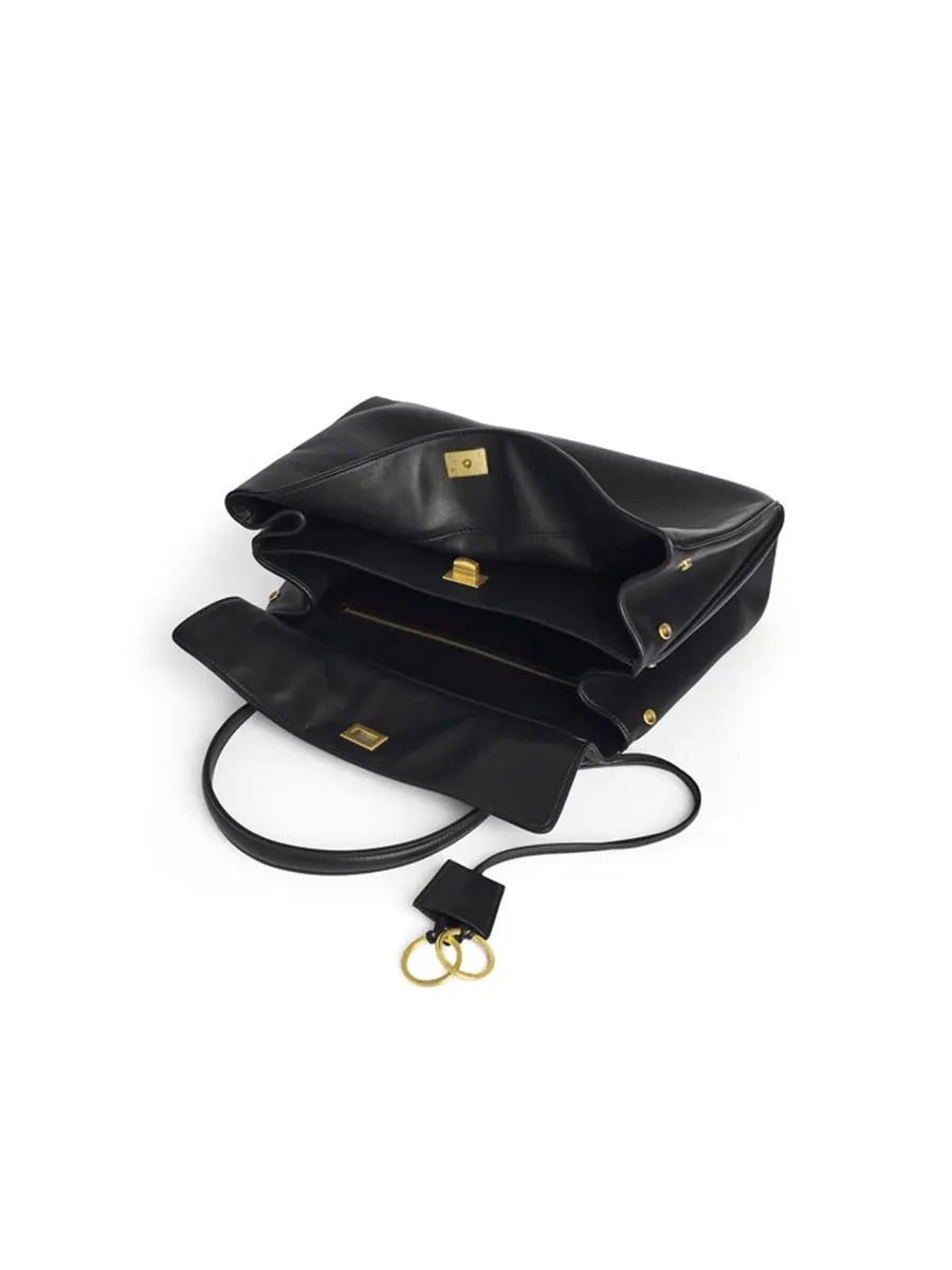 Black handbag with gold accents on a white background