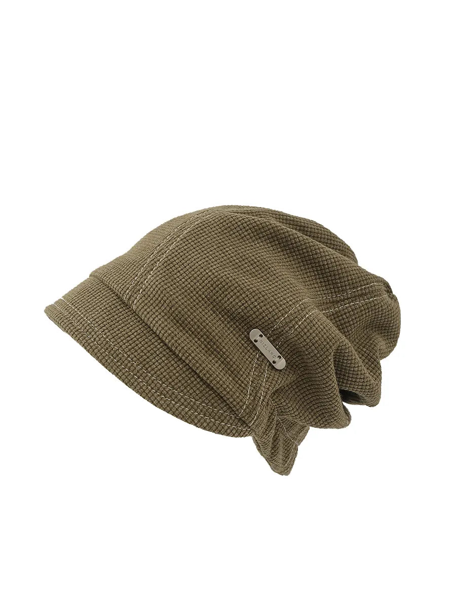 Brown knit beanie with a tag on a white background