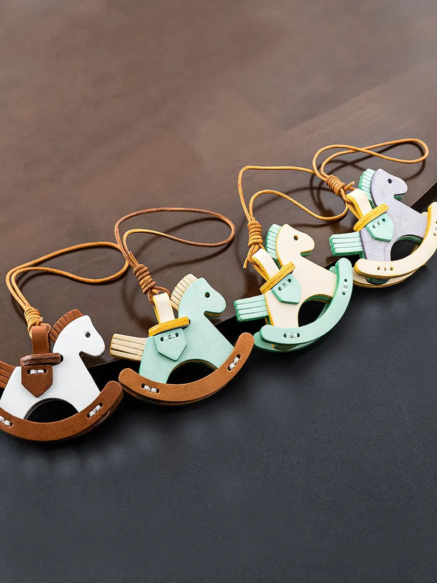 Set of rocking horse keychains on a dark surface
