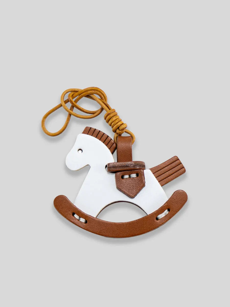 Riding horse keychain with a brown body and white face on a light gray background