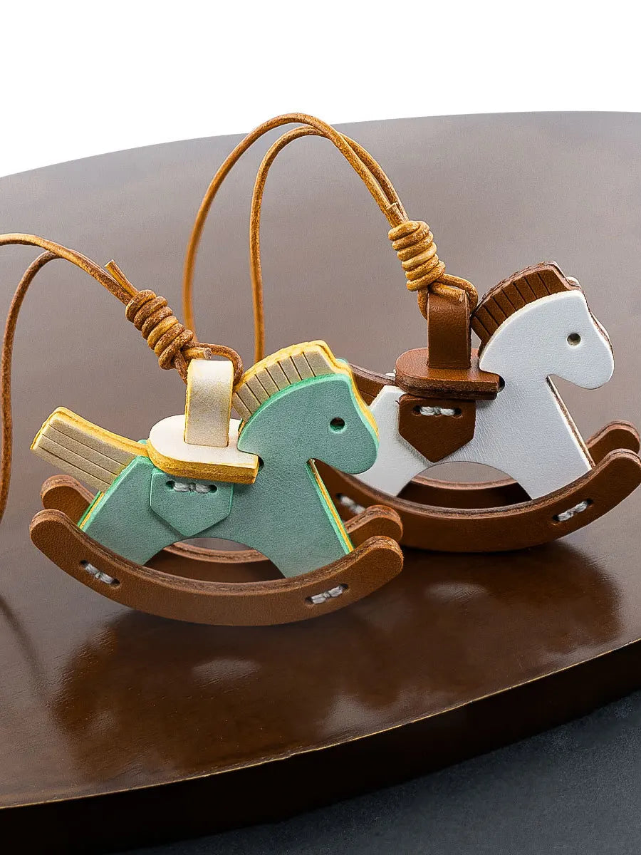Wooden rocking horse toy with a smaller green horse on a brown surface