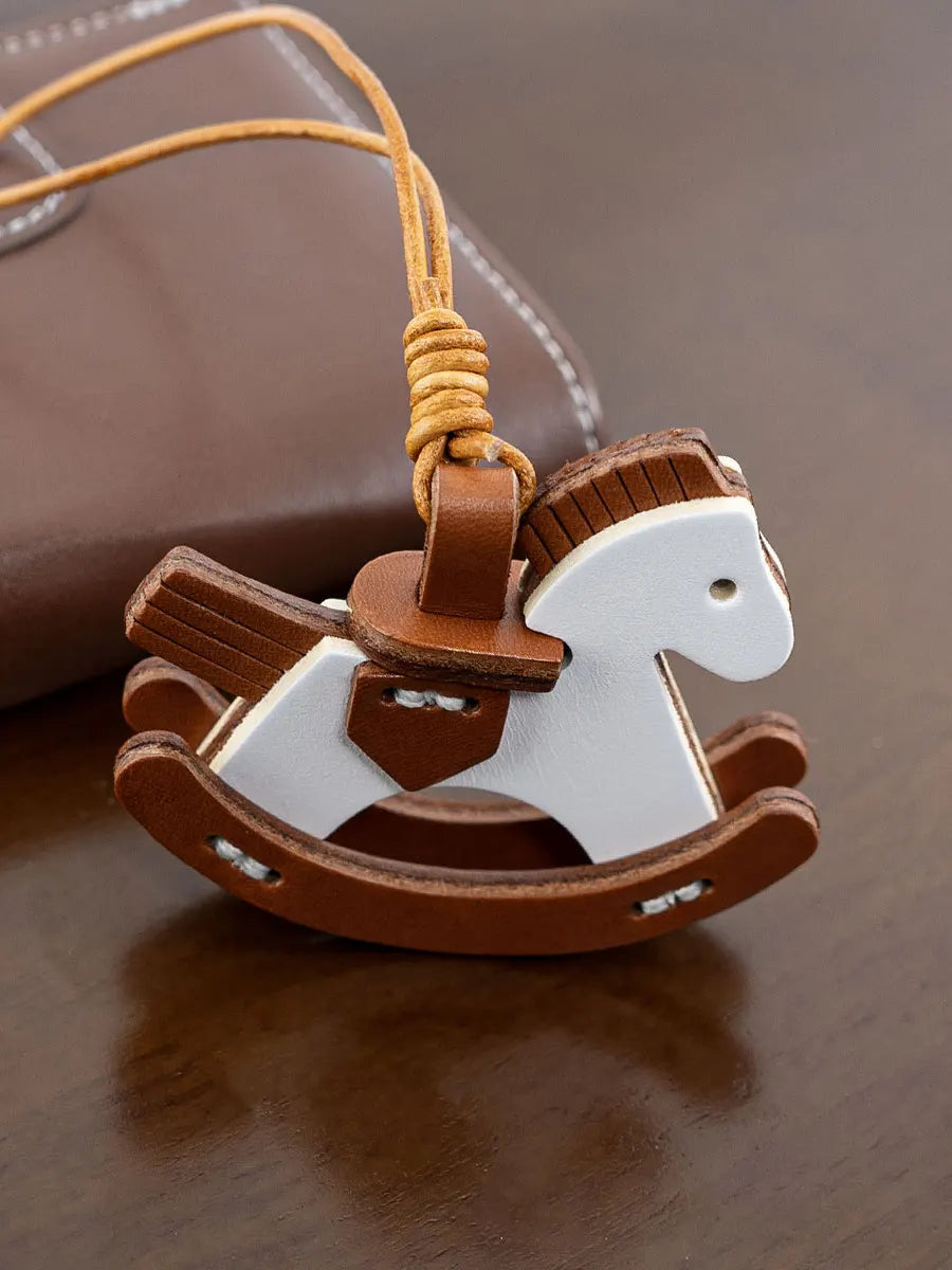 Wooden rocking horse keychain on a brown surface