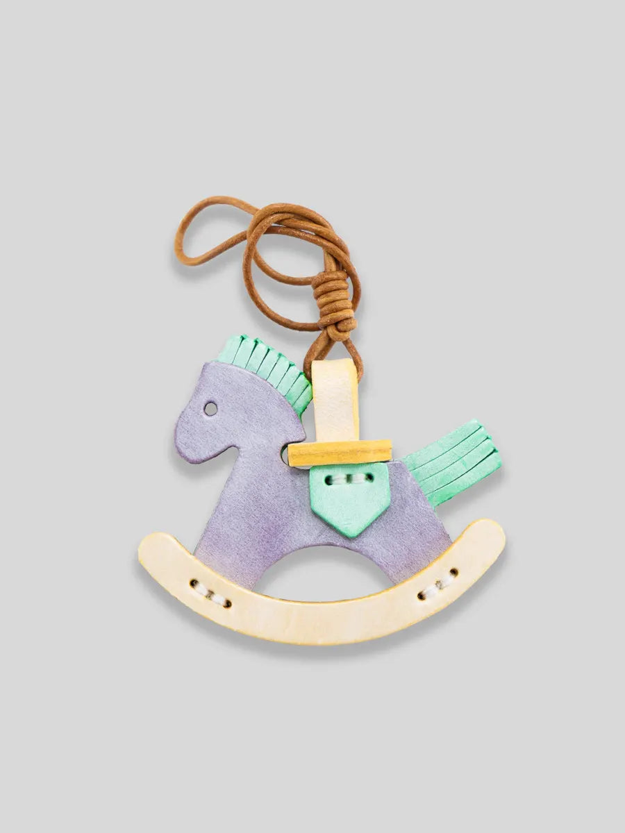 Riding horse keychain with a sword on a light gray background