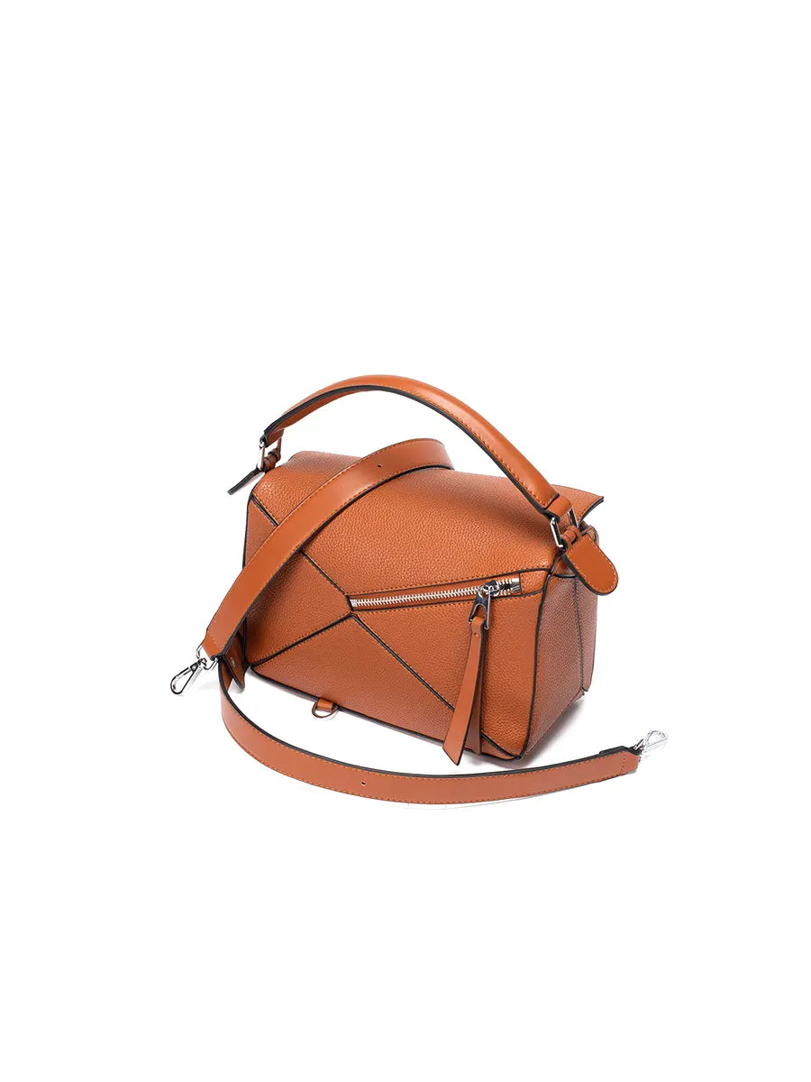 Brown leather handbag with a strap on a white background