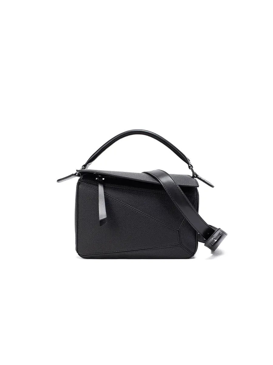 Black handbag with a strap on a white background