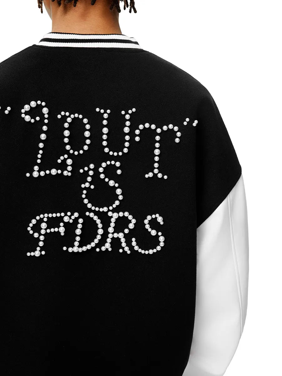 Black sweater with rhinestone-embellished text on the back, worn by a person.