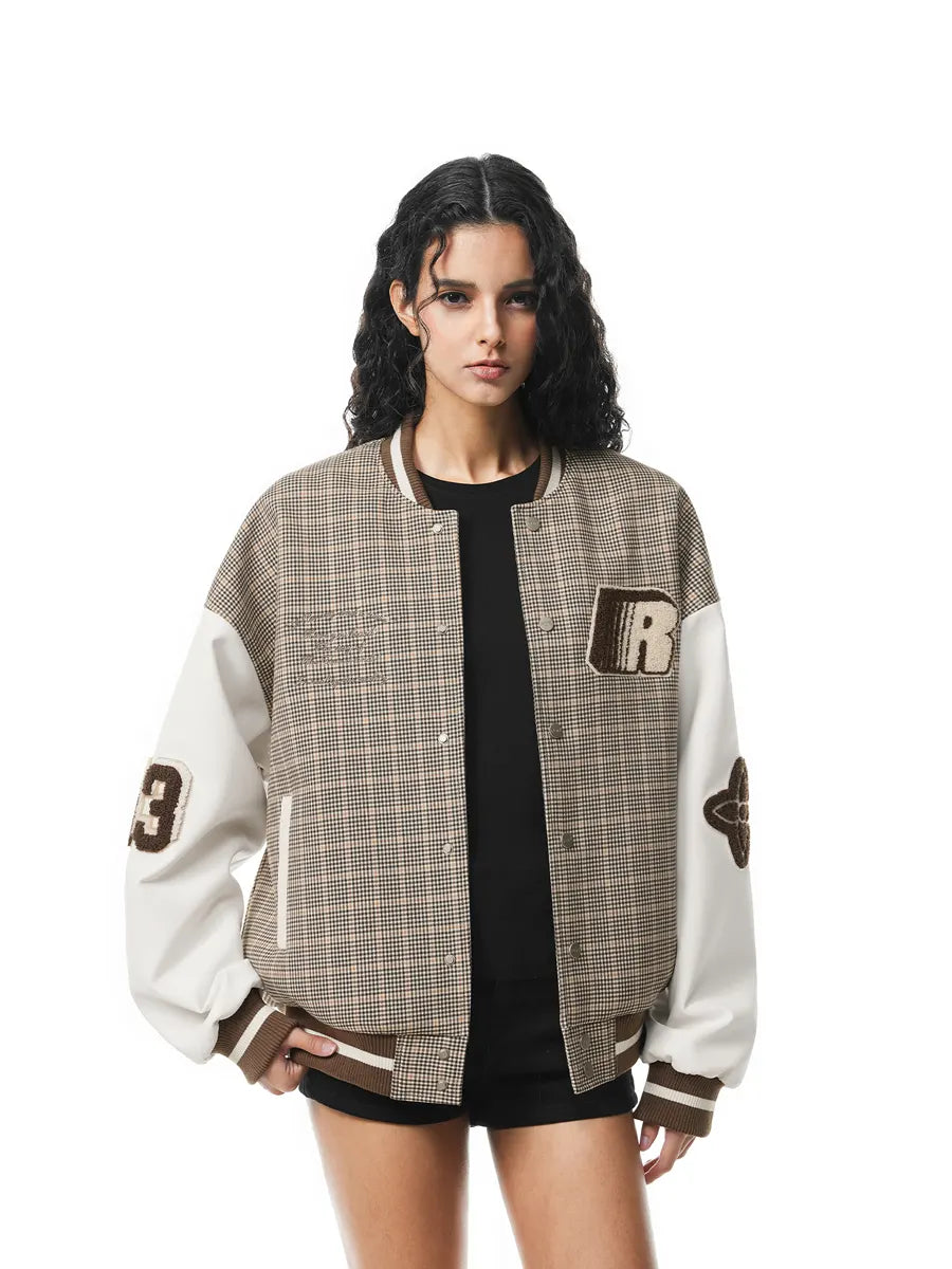 Woman wearing a plaid varsity jacket with a brand logo on a white background
