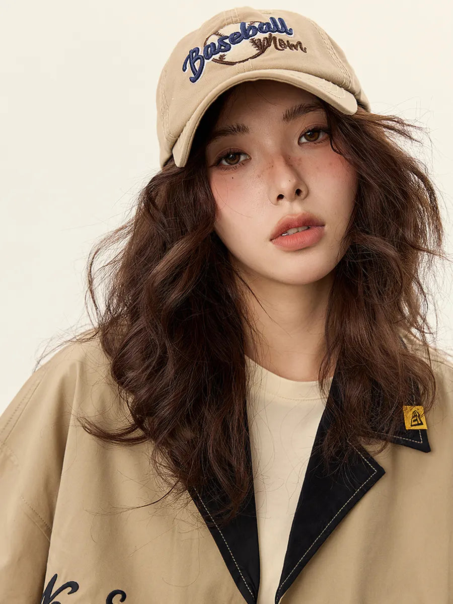 Woman wearing a beige cap and coat with a neutral background