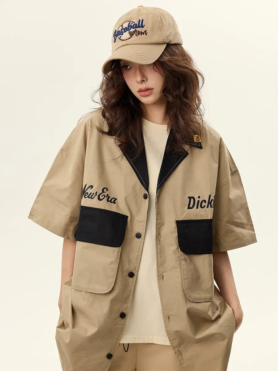 Person wearing a beige jacket with black accents and a matching cap on a beige background