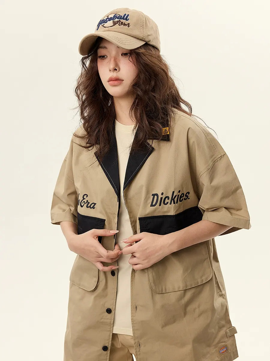 Person wearing a beige Dickies jacket and cap on a plain background