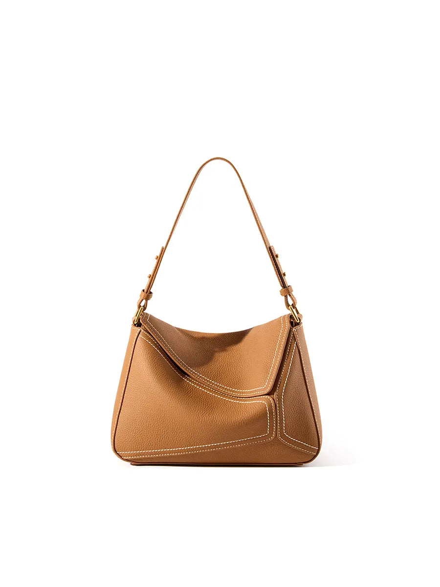 Tan handbag with a shoulder strap on a white background