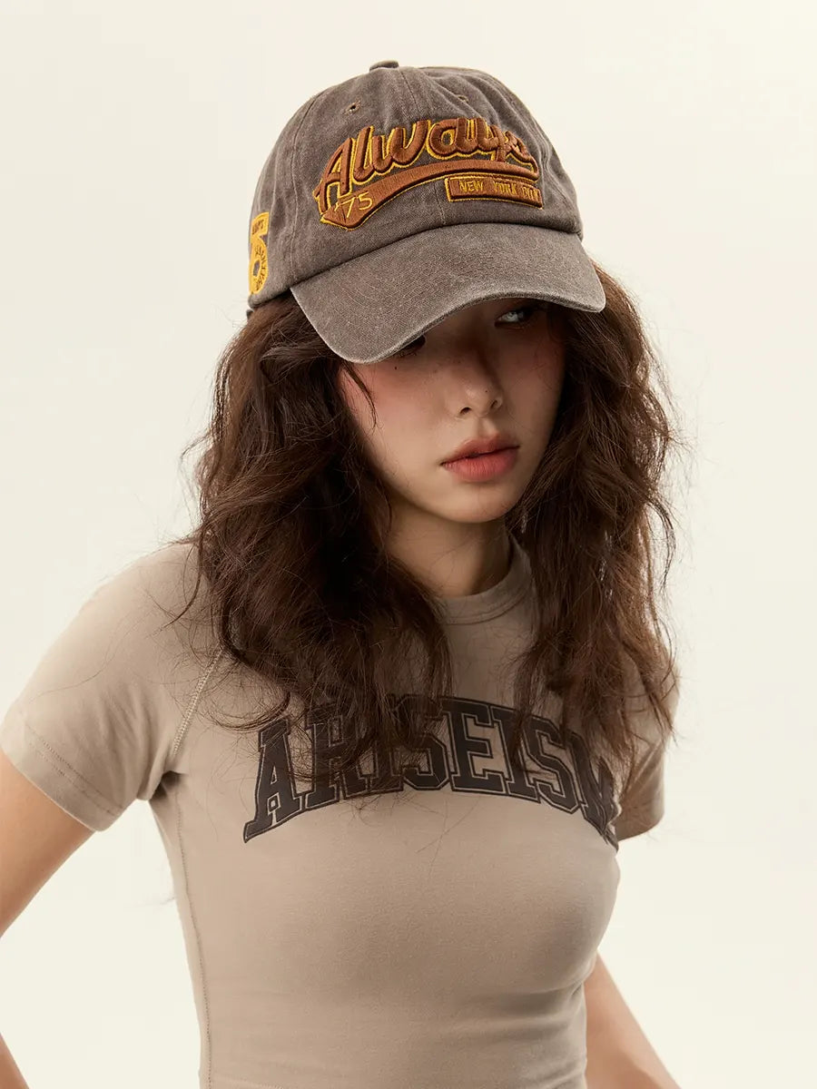 Woman wearing a cap and t-shirt with text on a plain background