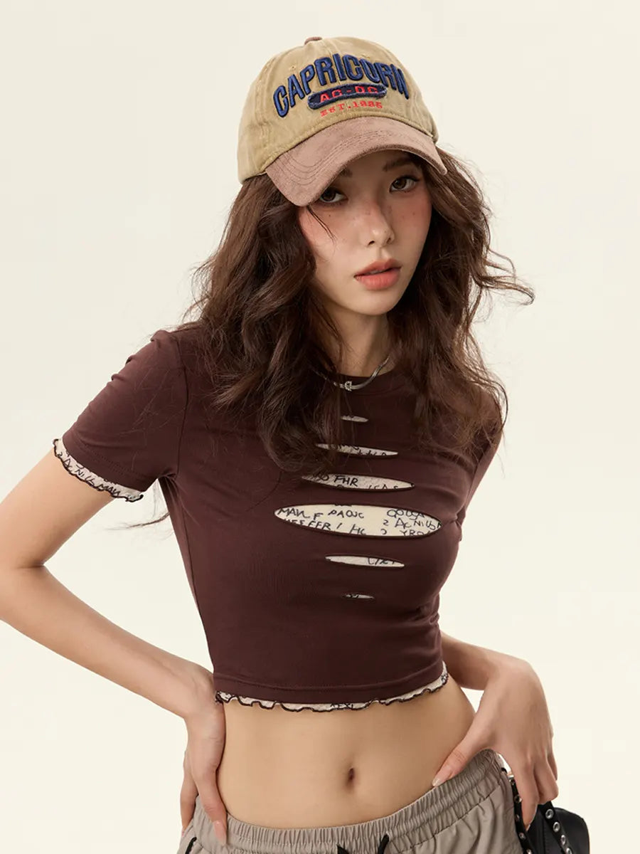 Woman wearing a brown distressed t-shirt and beige cap with 'Capricorn' text on a plain background