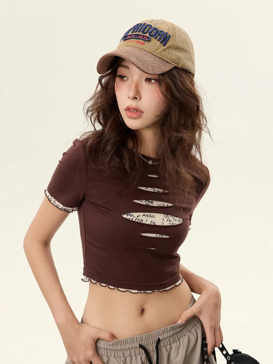 Woman wearing a brown distressed crop top and cap on a beige background