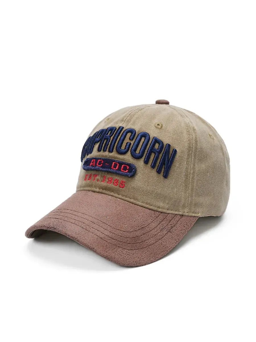 Beige and brown cap with 'Capricorn' and 'AC/DC' branding on a white background