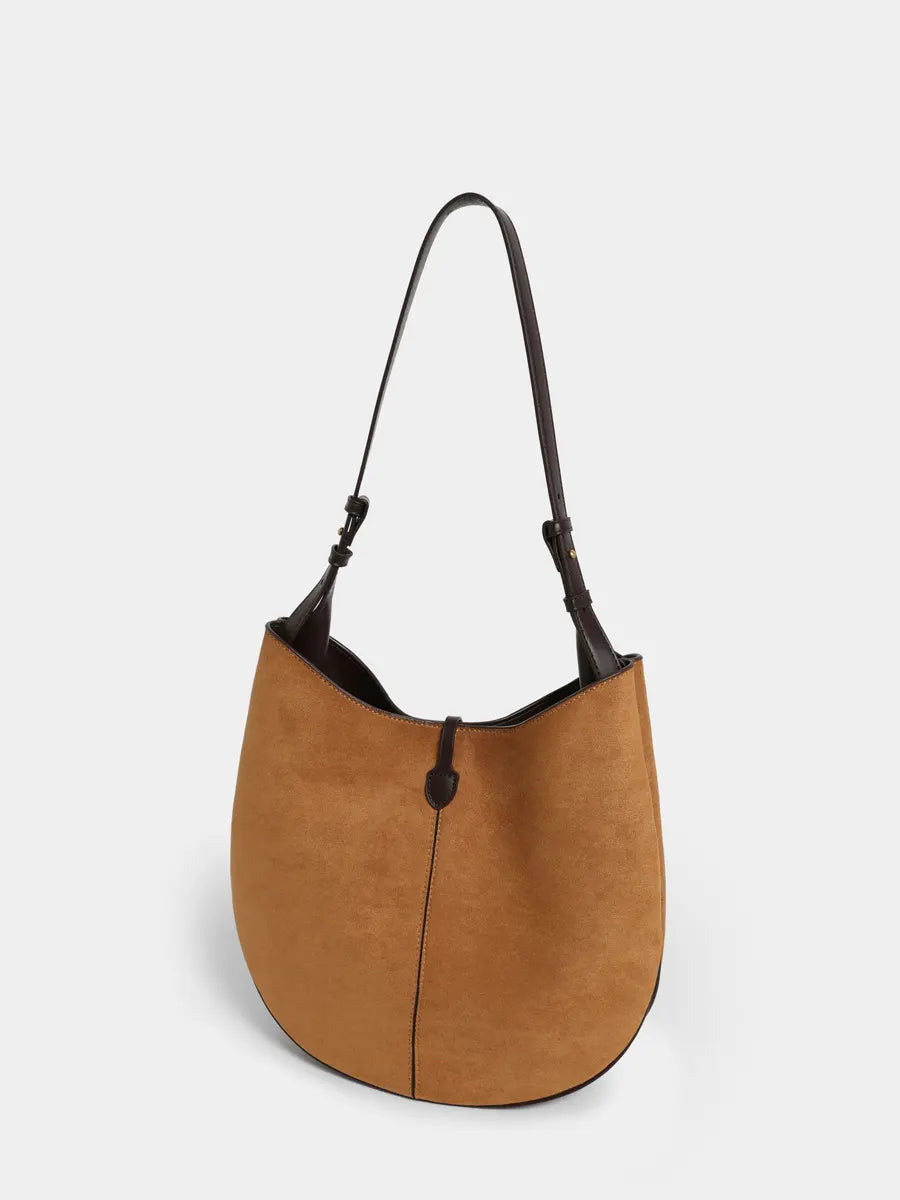 Brown handbag with black accents on a light gray background