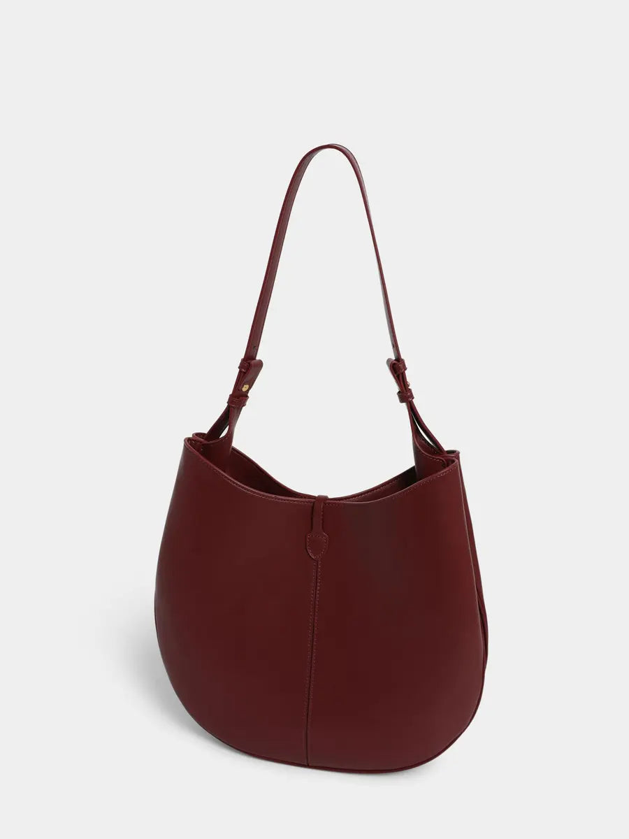 Brown leather handbag on a light gray background
