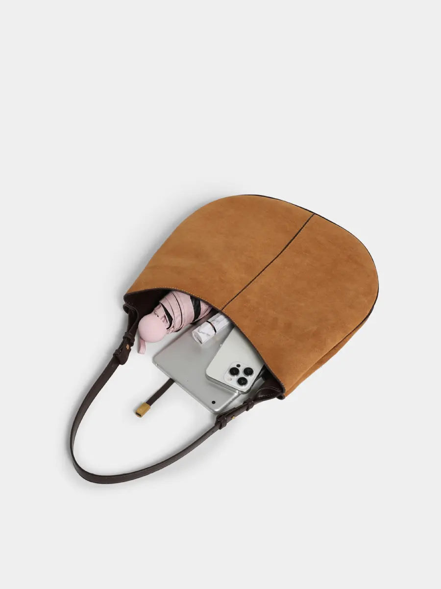 Brown leather pouch with a phone inside on a light gray background