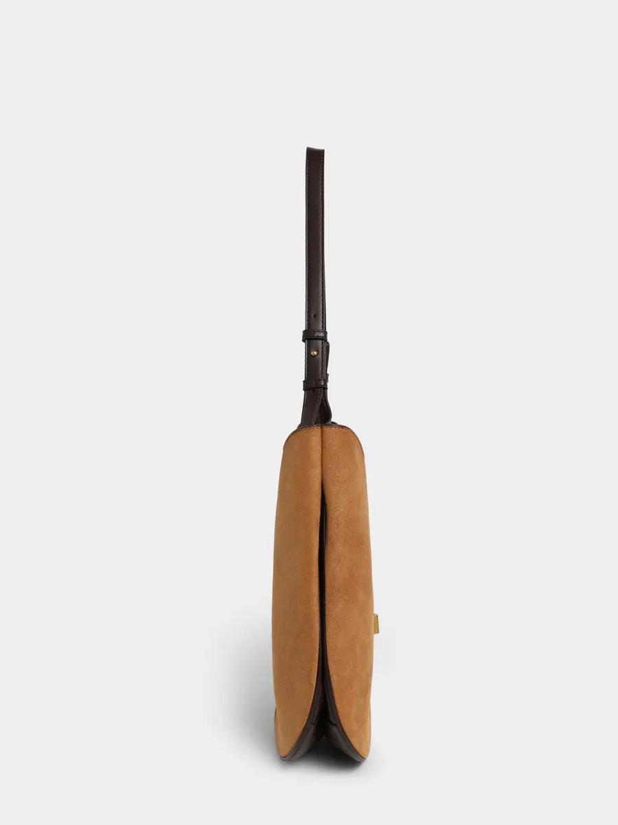 Tan leather paddle with black handle on a white background