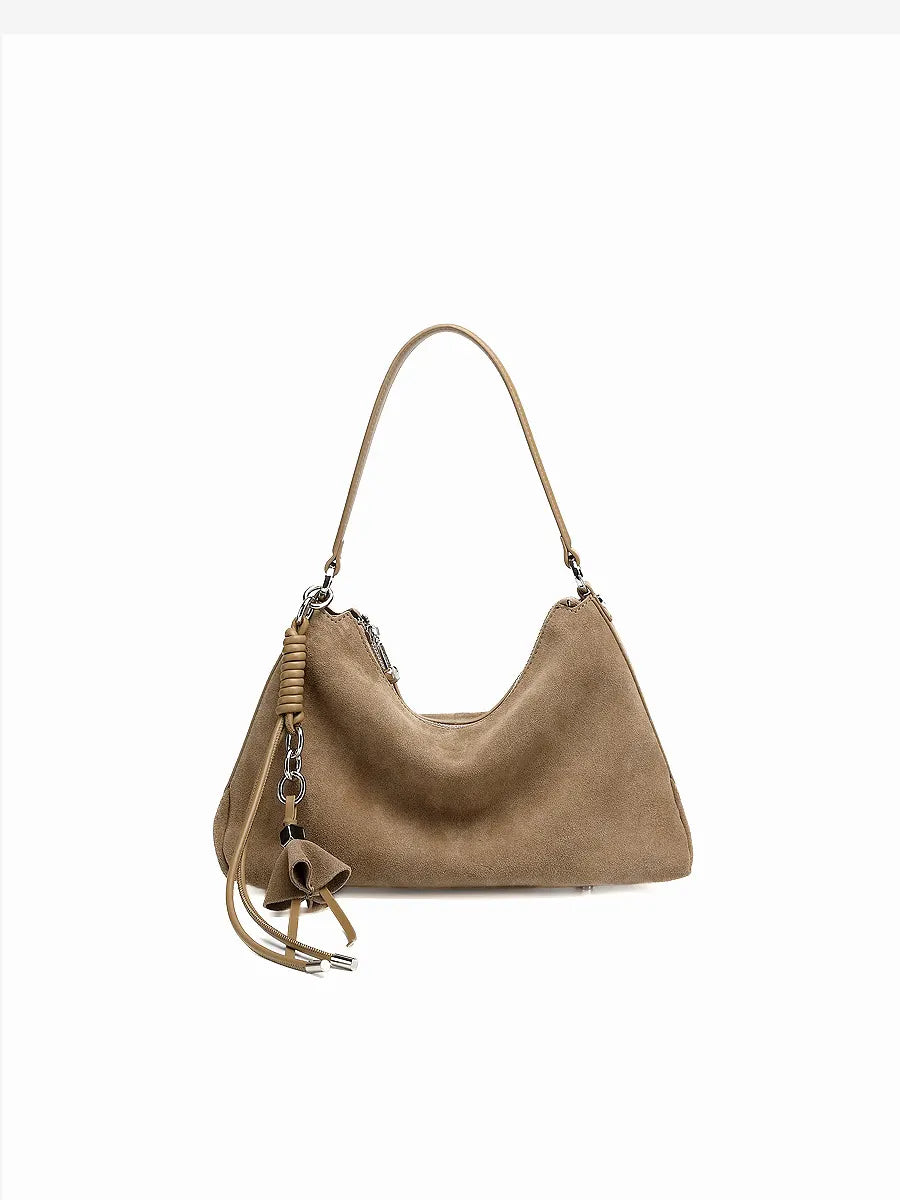 Brown handbag with decorative tassel on a white background