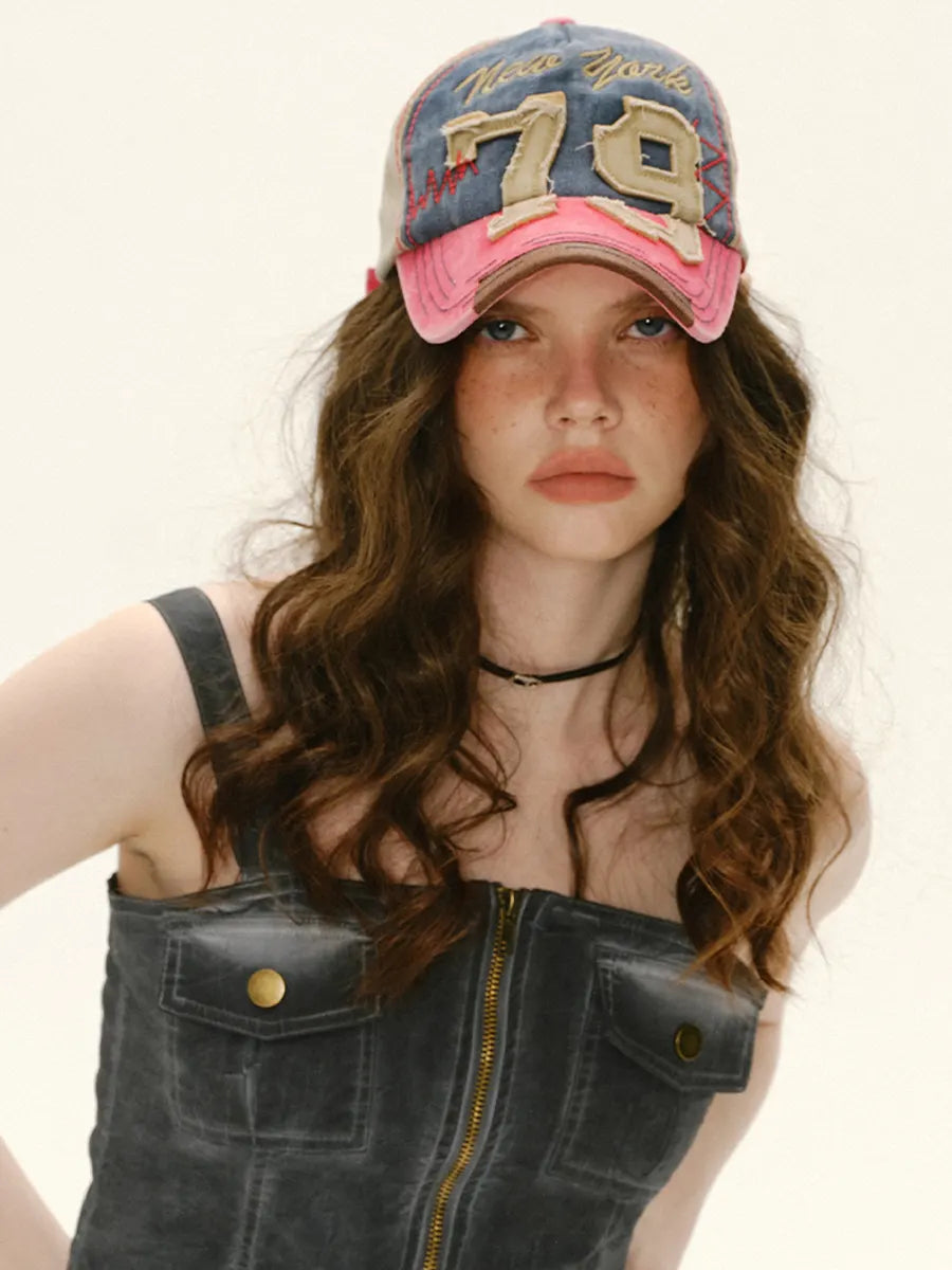 Woman wearing a pink and blue cap with '79' on a white background